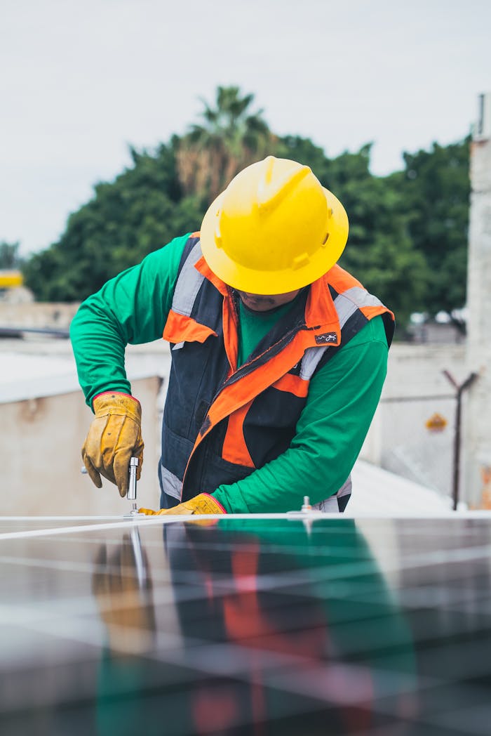 Professional solar panel technician working outdoors with PPE.